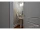 Cozy powder room with a pedestal sink, a decorative mirror, and a tiled floor at 447 Beacon Nw St, Concord, NC 28027