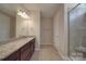 Bathroom with granite counters, wood cabinets, and a tiled shower at 5017 Willing Ct # 124, Indian Land, SC 29707