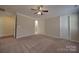 A large carpeted bedroom with neutral paint, trim, a ceiling fan, and multiple doors at 5017 Willing Ct # 124, Indian Land, SC 29707