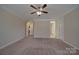 A large, carpeted bedroom with neutral paint, trim, a ceiling fan, and multiple doors at 5017 Willing Ct # 124, Indian Land, SC 29707
