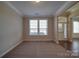 Neutral carpeted living room with large windows, white trim, and an open doorway to hardwood floors at 5017 Willing Ct # 124, Indian Land, SC 29707