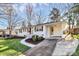 White brick home featuring a wide driveway and landscaped front yard, combining charm and convenience at 5110 Wedgewood Dr, Charlotte, NC 28210