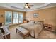 Serene main bedroom with tray ceilings, plantation shutters, and a cozy sitting area at 8107 Crater Lake Dr, Indian Land, SC 29707