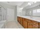 Well-lit bathroom featuring double vanity, shower, tile flooring and neutral colors at 8107 Crater Lake Dr, Indian Land, SC 29707
