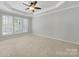 Bedroom with tray ceiling, ceiling fan, plenty of natural light, and neutral carpet at 8107 Crater Lake Dr, Indian Land, SC 29707