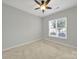 Well-lit bedroom featuring a ceiling fan and a large window for a bright and airy feel at 8107 Crater Lake Dr, Indian Land, SC 29707
