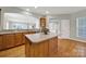 Kitchen island with granite countertop, wooden cabinets, and hardwood flooring at 8107 Crater Lake Dr, Indian Land, SC 29707