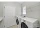 Laundry room with washer, dryer, shelving and natural light from a window at 8107 Crater Lake Dr, Indian Land, SC 29707