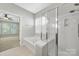 Main bathroom featuring a soaking tub, walk-in shower, and neutral tile for relaxation at 8107 Crater Lake Dr, Indian Land, SC 29707