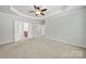 Spacious main bedroom with tray ceiling, ceiling fan, carpet floors and double doors at 8107 Crater Lake Dr, Indian Land, SC 29707
