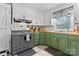 Updated kitchen with vintage stove, green cabinets, butcher block countertops, and white backsplash at 851 Gist Rd, Rock Hill, SC 29732