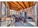 Relax on this cozy covered patio featuring wood ceiling, stone fireplace, and comfortable seating at 11207 Argosy Dr, Lancaster, SC 29707