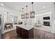 Open kitchen features an island with bar seating, stainless steel appliances, and stylish wooden light fixtures at 11207 Argosy Dr, Lancaster, SC 29707