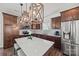 Modern kitchen features an island with bar seating, stainless steel appliances, and stylish wooden light fixtures at 11207 Argosy Dr, Lancaster, SC 29707