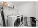 Modern laundry room with front load washer/dryer, wire shelving, and color-coded sorting bins at 11207 Argosy Dr, Lancaster, SC 29707