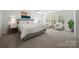 Bright main bedroom features neutral carpeting, a queen bed and a sitting area with tree views at 11207 Argosy Dr, Lancaster, SC 29707