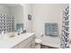 A clean bathroom with a big mirror, a clean white countertop, and a blue patterned shower curtain at 156 Sugar Hill Rd, Troutman, NC 28166
