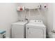 Laundry room with a newer white washer and dryer, with storage shelving above at 156 Sugar Hill Rd, Troutman, NC 28166