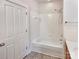 Bright bathroom features a white tub and shower with tiled walls, complemented by neutral flooring at 15604 Waterfront Dr, Huntersville, NC 28078