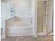Bright bathroom featuring a soaking tub, glass shower and neutral-colored tiling at 15604 Waterfront Dr, Huntersville, NC 28078