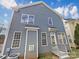 Side view of home with gray siding, multiple windows, and small patio at 15604 Waterfront Dr, Huntersville, NC 28078