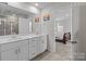 Bathroom with double sink vanity leading to bedroom with large window and Queen bed at 2116 Belterra Dr, Charlotte, NC 28216