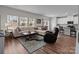 Open-concept living room featuring hardwood floors, a large sofa, and abundant natural light at 2116 Belterra Dr, Charlotte, NC 28216