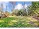 Expansive backyard featuring a wooden fence and a combination of open lawn and wooded areas that create a tranquil retreat at 2316 Winding River Dr, Charlotte, NC 28214