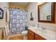 Well-lit bathroom featuring a wooden vanity, oval sink, and blue patterned shower curtain for a relaxing bath experience at 2316 Winding River Dr, Charlotte, NC 28214