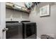Laundry room with gray front load washer and dryer and overhead storage shelves at 2455 Seagull Dr # 62, Denver, NC 28037