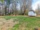 Large backyard features a storage shed and a fire pit with Adirondack chairs for entertaining at 2602 Cherokee Ct, Gastonia, NC 28056