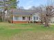 Charming one story home with a brick foundation, chimney, front porch, manicured lawn, and mature trees at 2602 Cherokee Ct, Gastonia, NC 28056