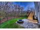 An outdoor space with a fire pit, deck with stairs, and a fence bordering a wooded area at 2835 Peverell Ln, Charlotte, NC 28270