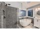 Modern bathroom with shower, tub, neutral tile, and stylish fixtures at 2835 Peverell Ln, Charlotte, NC 28270