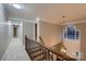 Upstairs hallway features dark wood stair railing and decorative window providing natural light at 2835 Peverell Ln, Charlotte, NC 28270