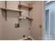 Functional laundry room featuring built-in shelving and utility connections at 2835 Peverell Ln, Charlotte, NC 28270