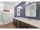 Bathroom with dual vanities, framed mirrors, dark blue walls, and a walk-in shower, exuding contemporary elegance at 3017 Woodlands Creek Dr, Monroe, NC 28110