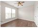 Bedroom features hardwood floors, a ceiling fan, and natural light from a large window at 3017 Woodlands Creek Dr, Monroe, NC 28110