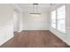 Dining room features hardwood floors, wainscoting, modern light fixture, and natural light at 3017 Woodlands Creek Dr, Monroe, NC 28110