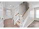 Hallway featuring wood floors, white trim, and a staircase leading to the upper level at 3017 Woodlands Creek Dr, Monroe, NC 28110