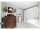 Charming bathroom with vintage dresser, hexagon tile floors, and a shower with white curtain at 308 W First St, Lowell, NC 28098