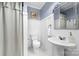 Updated bathroom with white wainscotting, white fixtures, and white tile flooring at 308 W First St, Lowell, NC 28098