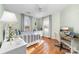 Well-lit bedroom features hardwood floors, neutral colored walls, and a desk area for work or studying at 308 W First St, Lowell, NC 28098