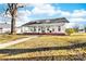 Inviting white home showcasing a sprawling porch with classic columns and shaded seating areas at 308 W First St, Lowell, NC 28098