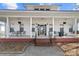 Inviting front porch with brick accents, decorative columns, seating and glass front door at 308 W First St, Lowell, NC 28098