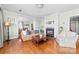 Cozy living room featuring hardwood floors, fireplace, comfortable seating, and view into dining room at 308 W First St, Lowell, NC 28098