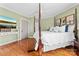 Spacious bedroom with a four poster bed, hardwood floors, and sage green walls at 308 W First St, Lowell, NC 28098
