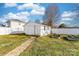 White shed in backyard with a walkway and garden beds offering storage and charm at 308 W First St, Lowell, NC 28098