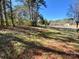Picturesque backyard featuring a well-manicured lawn, scattered trees, and a rustic fence under a clear blue sky at 3807 Woodlawn St, Sharon, SC 29742