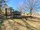 Backyard featuring a fire pit and view of the home's exterior with mature trees at 3807 Woodlawn St, Sharon, SC 29742